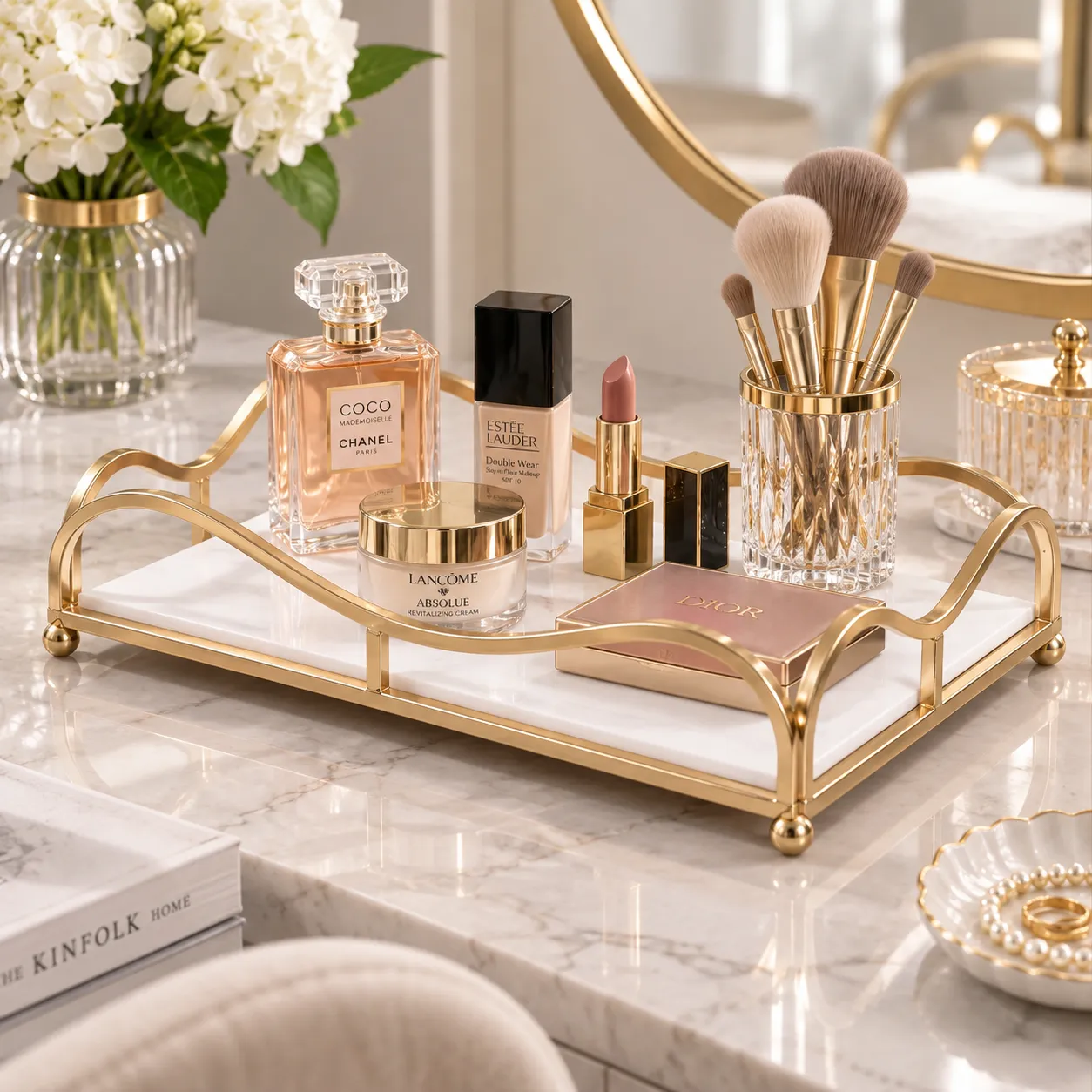Gold mirror finish vanity tray styled with florals and perfume bottles near a mirror
