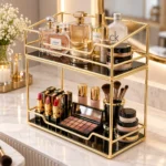 Golden 2 tier makeup organizer holding cosmetics and perfume bottles on a vanity