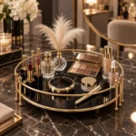 Round gold vanity tray styled with candles, perfume bottles and floral decor