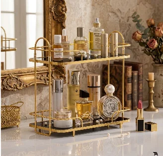 Golden 2 tier perfume organizer rack holding perfume bottles and lipsticks on a white vanity next to a window
